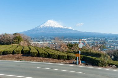 Fuji Dağı, Yamamoto, Fujinomiya, Shizuoka Bölgesi, Japonya 'da karlı ve yeşil çay tarlasına sahip. Trafik aynalı sokak. Fujinomiya şehrinin ve Shin-Tomei otoyolunun havadan görünüşü. 