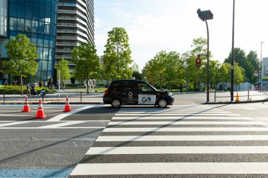 Shinjuku Şehri, Tokyo, Japonya - 12 Haziran 2021: Tokyo 2020 Olimpiyat Oyunları. Toyota taksi Japon Spor Olimpiyat Meydanı 'nın önünden geçiyor, Japonya Olimpiyat Müzesi.