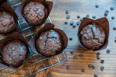 Kahverengi kağıt bardaklarda çikolatalı kek, ahşap kesim yaban domuzu.