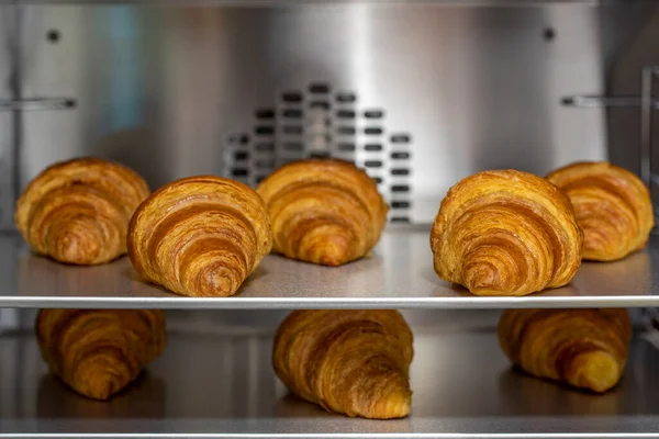 Baking tray with delicious croissants in oven