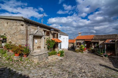 Belmonte, Portekiz; Mayıs 2017: Issız bir sokak ve Belmonte 'de güneşli bir günde azizler için taş oyuğu olan sevimli eski bir ev. Portekiz 'in doğusunda seyir subayı Pedro Alvares Cabral' ın küçük şirin bir kasabası..