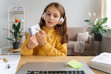 İnternet kamerasında, koronavirüs karantinası nedeniyle uzaktan internet toplantı uygulaması ile öğretmeniyle çevrimiçi ders alan genç bir kız görülüyor. Egzersiz yapıyor ve soru soruyor. Evde eğitim