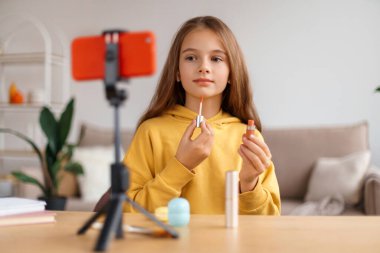 Ünlü kız blogcu, akıllı telefon webcam ve tripodu kullanarak takipçileri ve aboneleri için evden yayın yapıyor. Makyaj ve kozmetik hakkında çevrimiçi dersler çekiyor. Karantina eğlencesi, çocuk medyası