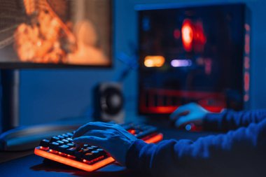 Profesyonel oyuncuların ellerini neon renkli, bulanık arkaplanlı klavyeye yakın tut. Birinci şahıs nişancı. Profesyonel siber sporcu evde online video oyunları oynuyor, turnuvaya katılıyor. Yumuşak odak.