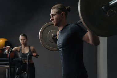 Beyaz, genç ve sportif bir çift spor salonunda birlikte çalışıyor. Çapraz donanımlı grup işlevsel devre eğitimi. Erkek ve kadın spor kulübünde eğitim görüyor.