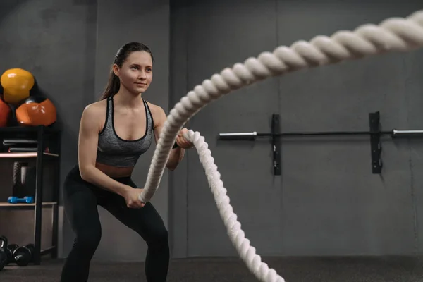 健美女子身强力壮的形象在功能性训练交叉黑衣体操馆进行锻炼 运动的年轻女子使用钢丝绳在功能性训练体育馆做运动 — 图库照片