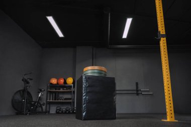 Boş, karanlık, uygun spor salonu. Spor için profesyonel spor ekipmanları, halter, ağırlık kaldırma, fitness, yaya geçidi. Sıçrama kutusu, ağırlık, hava bisikleti. Boşluğu kopyala