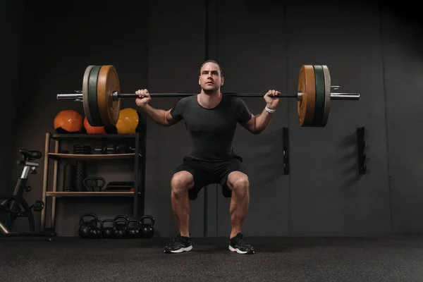 Muskelkräftiger Crossfit Athlet Beim Kniebeugen Mit Der Langhantel Dunklen Fitnessstudio — Stockfoto