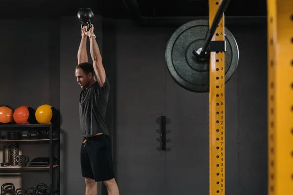 Podnośnik Mięśni Robi Ćwiczenia Kettlebell Ciemnym Crossfit Siłowni Profesjonalnym Sprzętem — Zdjęcie stockowe