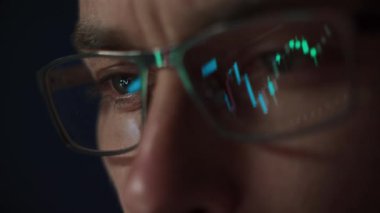 Karanlık ofisteki kripto para piyasasını analiz ederken lenslere yansıyan borsa endeksli gözlük takan odaklı kripto simsarını kapat. Kripto ticareti ve yatırımı