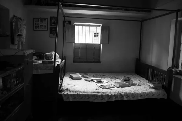 Black and white empty room with opened window and books on the bed