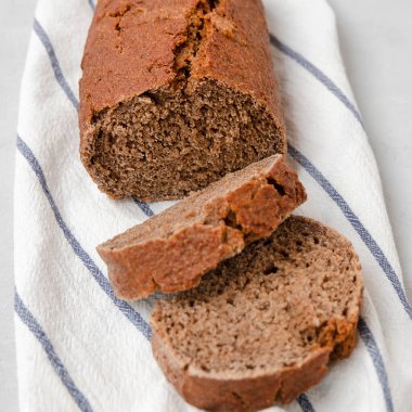 Beyaz mutfak havlusunda dilimlenmiş tam tahıllı çavdar ekmeği..