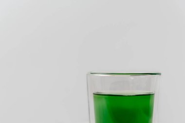 Sağlıklı içecek sıvı klorofil özü ve beyaz arka planda bir bardak su.