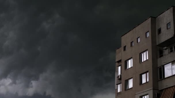 Rychle se pohybující náladové tmavé bouřkové mraky se silným větrem ve městě s budovou na jedné straně — Stock video