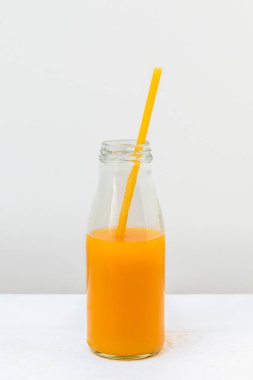 Hafif arka planda meyve suyu ve makarna dolu cam şişe, dikey görüntü
