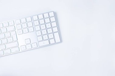 Beyaz arka planda beyaz ve gümüş renkli modern klavye. Serbest çalışma kavramı, evden çalışma, daktilo, çeviri. Boşluğu kopyala