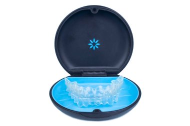 Isolated container with transparent invisalign aligner retainers or removable braces on white background clipart