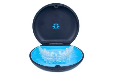 Isolated container with transparent invisalign aligner retainers or removable braces on white background clipart