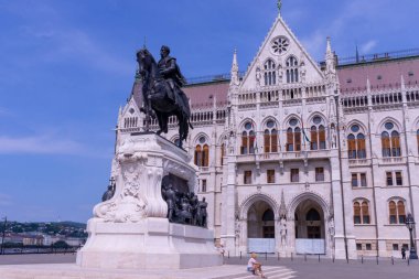 BUDAPEST, HUNGARY - 19 Ağustos 2021: Macaristan parlamento binası ve güneşli bir günde Budapeşte 'de önünde Kont Gyula Andrassy' nin heykeli