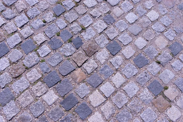 Old cobblestone pavement close-up background and texture