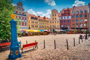 Geleneksel mavi su pompası, Stettin şehrinin amblemi ve arka planında eski kasaba meydanı arması olan gryphon başlıklı.