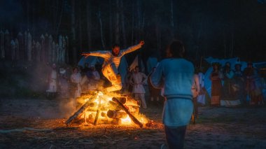 Cedynia, Polonya, Haziran 2019 'da Kupala Gecesi' nin Pagan canlandırması, Polonya 'da Noc Kupaly olarak anılıyor. Cesaretini gösteren adam şenlik ateşinin üzerinden atlıyor. Slav bayramı yılın en kısa gecesinde kutlandı