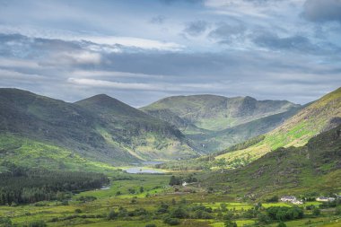 Geniş ve görkemli Kara Vadi 'de güneş ışığı ve bulutlardan gölgelerle kaplı gölgeli gölgeli gölgeli evler, Kerry İrlanda Halkası