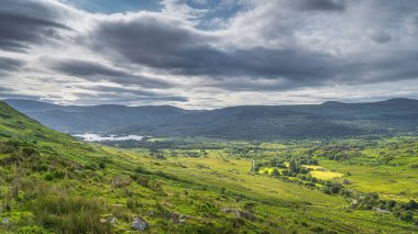 Geniş ve görkemli Kara Vadi 'de güneş ışığı ve bulutlardan gölgelerle kaplı gölgeli gölgeli gölgeli evler, Kerry İrlanda Halkası
