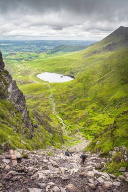 İrlanda 'nın en yüksek dağlarından biri olan Şeytan Merdiveni' ne tırmanan bir grup dağcı İrlanda 'nın en yüksek dağı Carrauntoohil' e ulaşmak için İrlanda Halkası, Kerry 'de tırmanıyor.