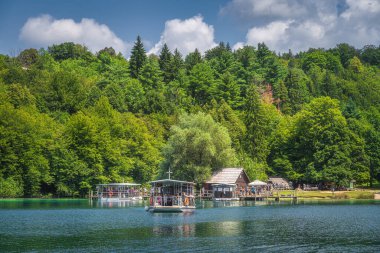 Plitvicka Jezera, Hırvatistan, Temmuz 2019 Feribot turistlerle birlikte gölü geçmek için küçük limandan ayrılıyor. Plitvice Lakes Ulusal Parkı UNESCO Dünya Mirası