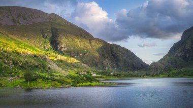 Dağlar ve Kara Göl gün batımında Dunloe, Kara Vadi, MacGillycuddys Reeks dağları, Kerry Halkası, İrlanda 'da gün batımında aydınlandı.