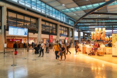 Berlin, Germany 8 Aug 2021 An energetic and bustling Brandenburg Airport terminal filled with diverse travelers, a variety of dining options, and large windows that allow for abundant natural light