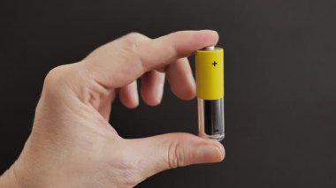 Eli bataryayı tutuyor. Geri dönüşüm veya enerji enerjisi kavramı