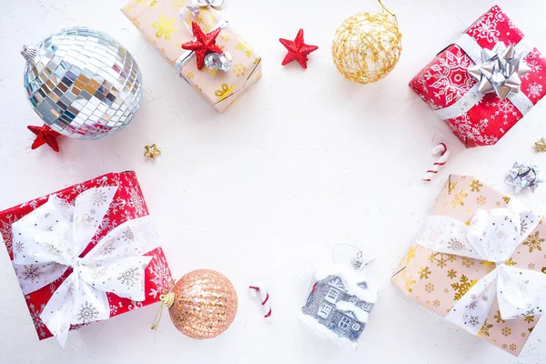 クリスマスプレゼント クリスマスボール 赤い星 弓と白いテーブルの上にディスコボール コピースペース — ストック写真
