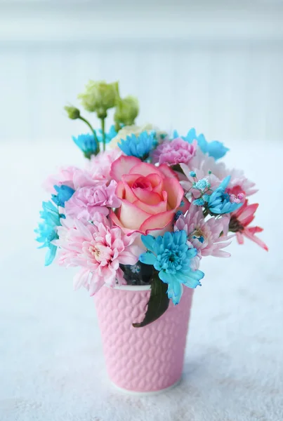 Beautiful bouquet of flowers in a pink glass on the table