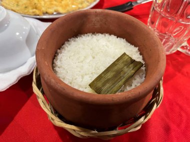 Geleneksel Vietnamlılar, kırmızı masada servis edilen kilden bir tencerede beyaz pirinç pişirirlerdi..