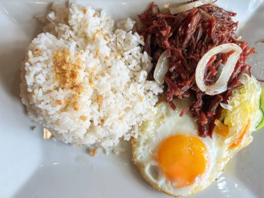 Delicious Corned Beef with Garlic Rice and Fried Egg on Plate.