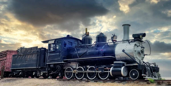 旧铁火车发动机后面戏剧性的落日 — 图库照片