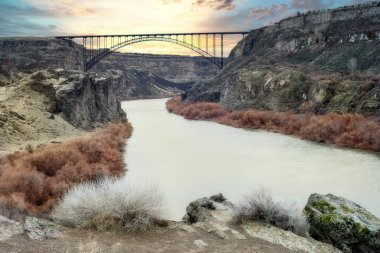 Gün doğumunda Yılan Nehri üzerindeki köprüde.