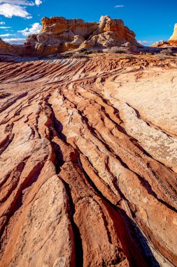 Bulutlara doğru giden kırmızı kayaların üzerindeki mavi gökyüzü