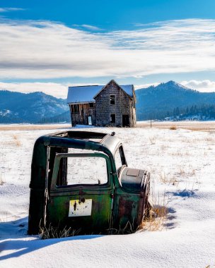 Terk edilmiş bir çiftlikteki kardaki kamyonetin kabuğu.
