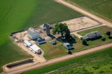 Ahırı ve ekinleri olan bir çiftliğin havadan görünüşü.
