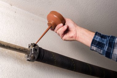 Garaj yayı ve sürgüye yağ döken tamirci.