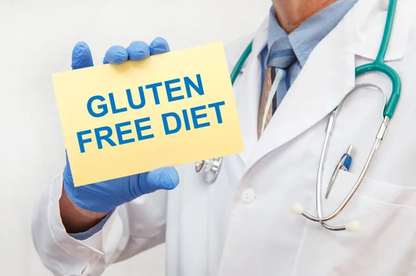 Close-up of a male doctor in gloves holding a sign with the text GLUTEN FREE DIET