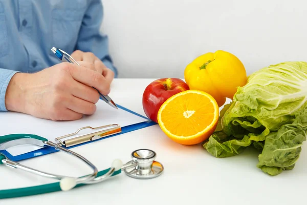 栄養士の医師は テーブルの上に食事計画を書く 正しい栄養と痩身コンセプト — ストック写真