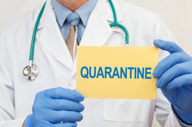 Doktor QuaranTINE 'a yakın çekim işareti tutuyor. Koronavirüs salgını sırasında karantina