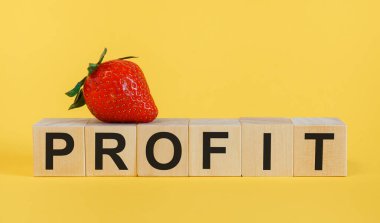 Sarı zemin üzerinde kısaltma PROFIT olan tahta küpler