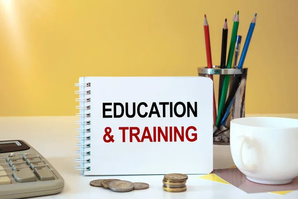 EDUCATION and TRAINING is written on a notepad, on an office desk with office accessories.