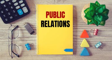Halkla İlişkiler, bir ofis masasının üzerindeki defterde ofis malzemeleriyle birlikte yazılır..
