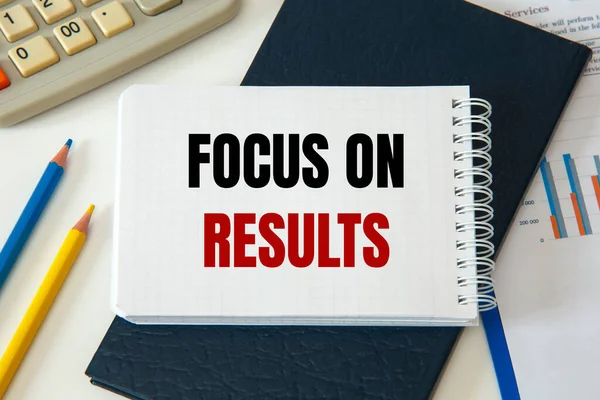 Focus on results is written on a notepad, on an office desk with office accessories.